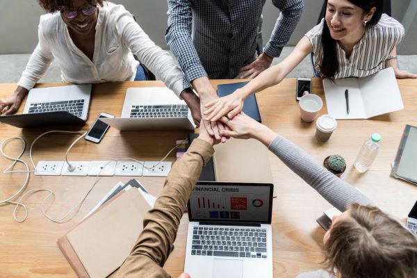 Un equipo de trabajadores juntando las manos